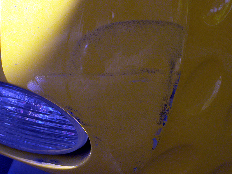 Detail of minor body scuffs on right rear panel, to right of backup light.